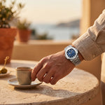 VALROX GENEVE steel dress watch worn on the wrist at a wooden table
